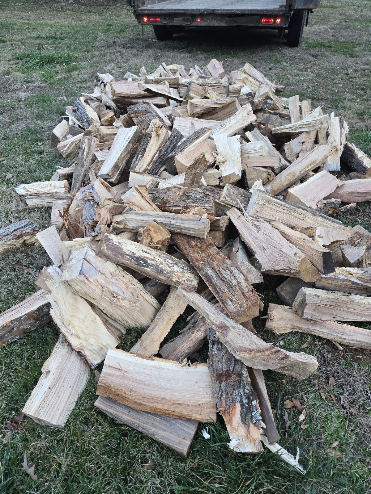 Split firewood piled beside a truck
